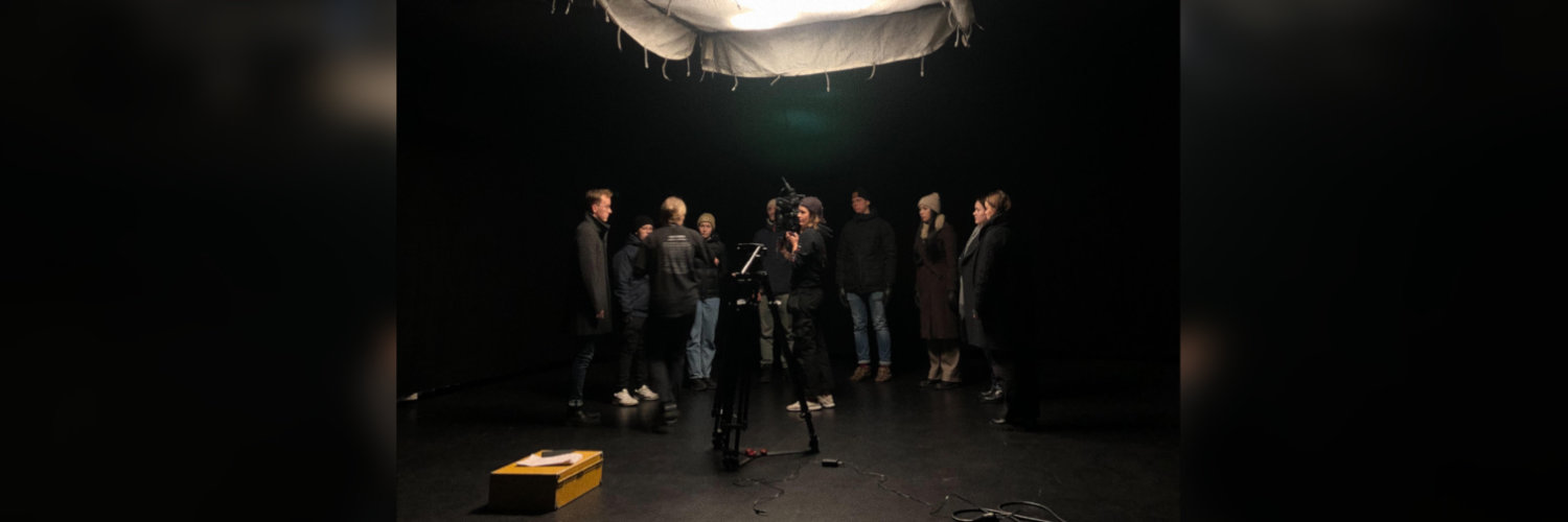 Bild från inspelning. Flera människor står i ett mörkt rum med kamera. Bild: privat.
